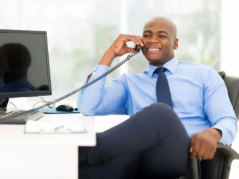 A businessman taking a phone call while leaning back in his chair