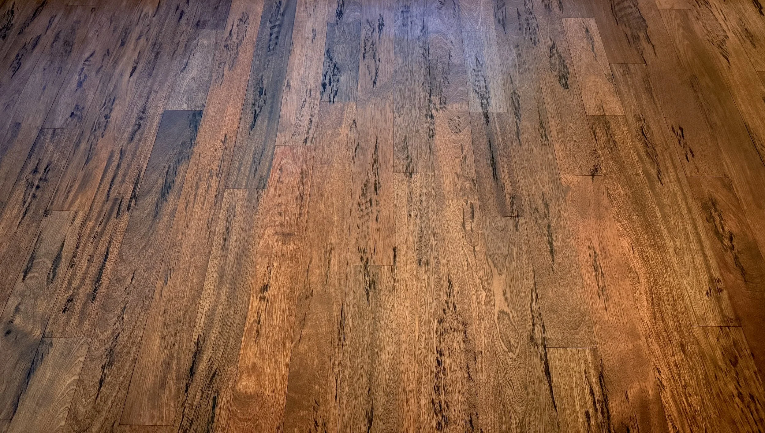 A hardwood floor with various shades of brown and visible wood grain.