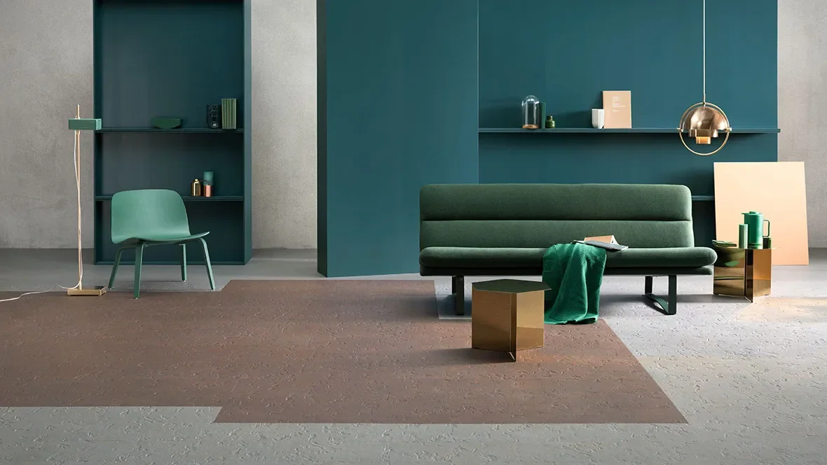 Modern living room with green sofa, green chair, gold side table, and shelf with decor against teal wall
