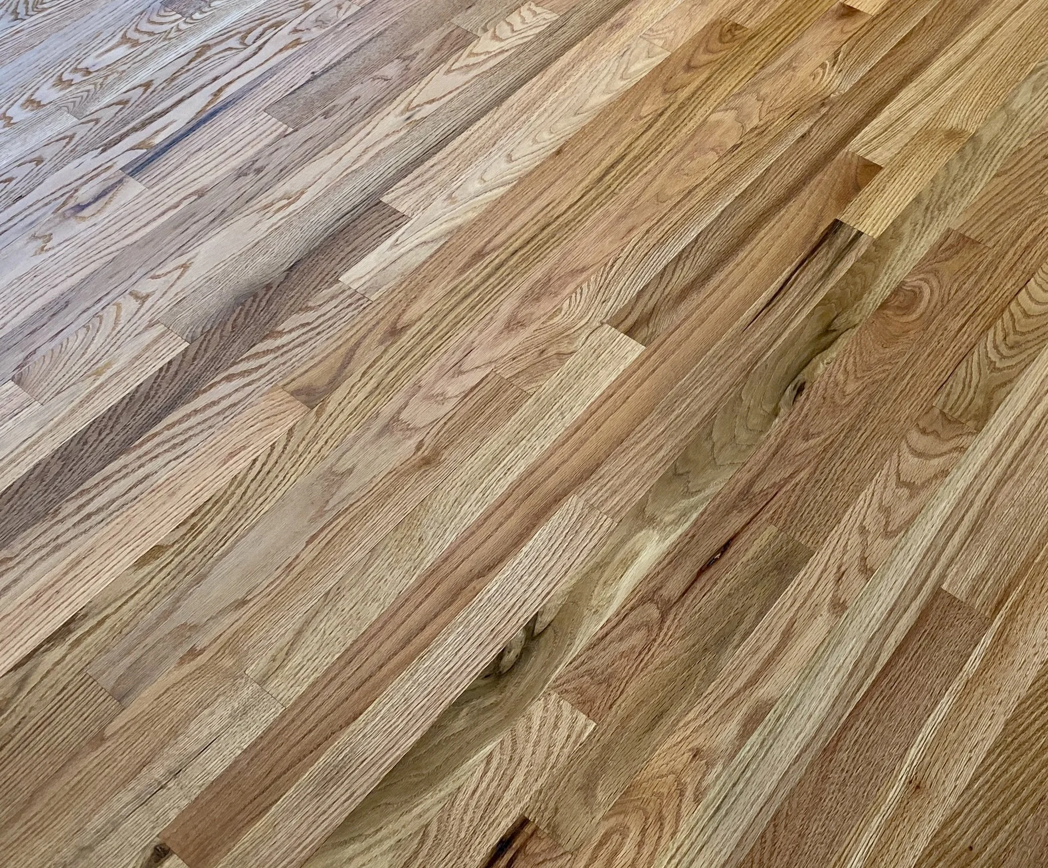 Close-up of a hardwood floor with a mix of different wood grain patterns and colors.