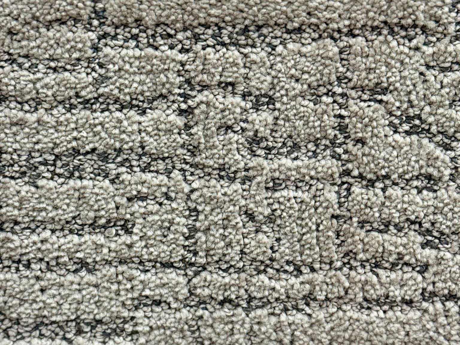 light grey cut pile carpet with darker loops combined to form a pattern