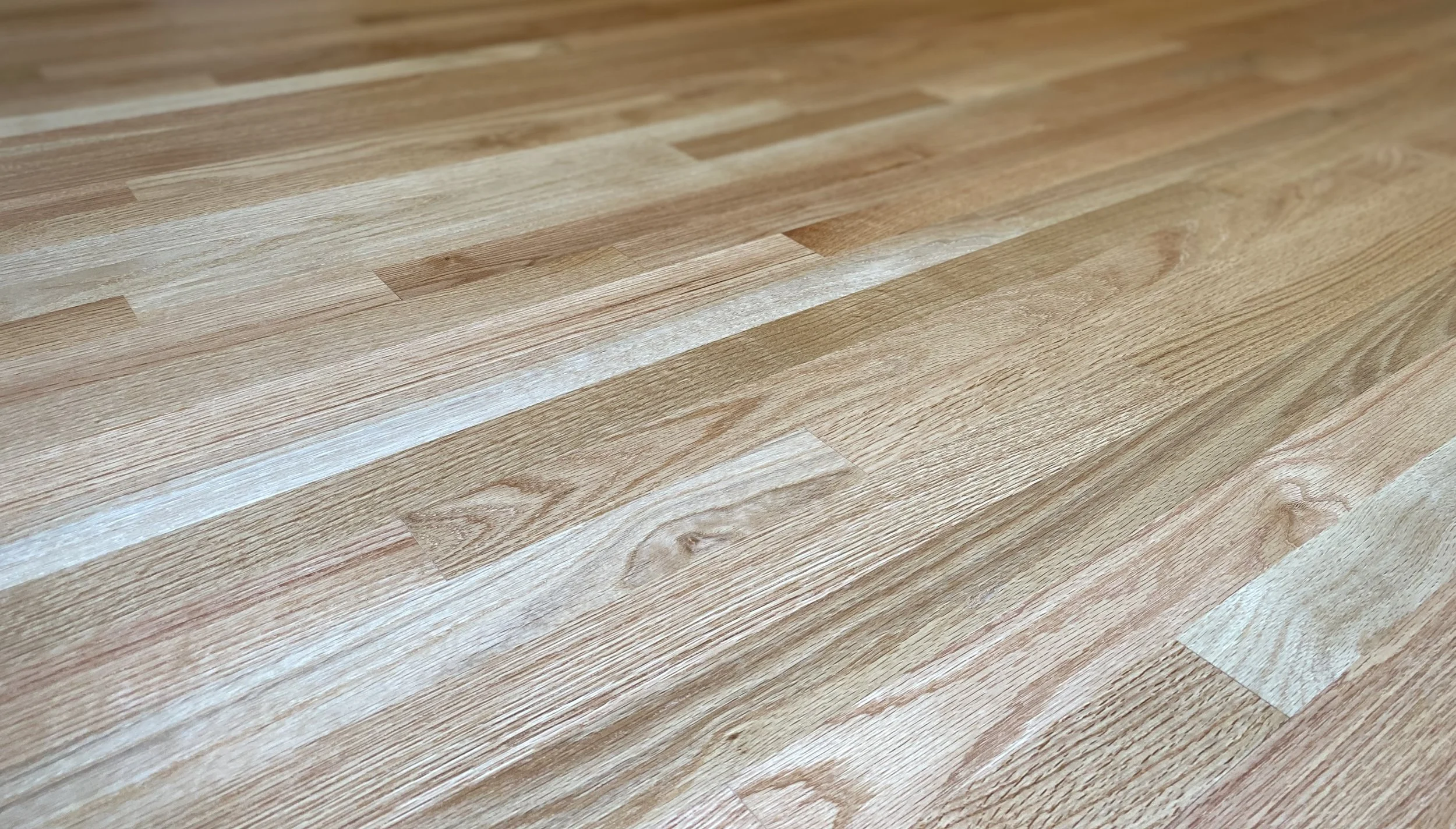 Close-up of a wooden floor with light and dark wood planks arranged in a pattern.
