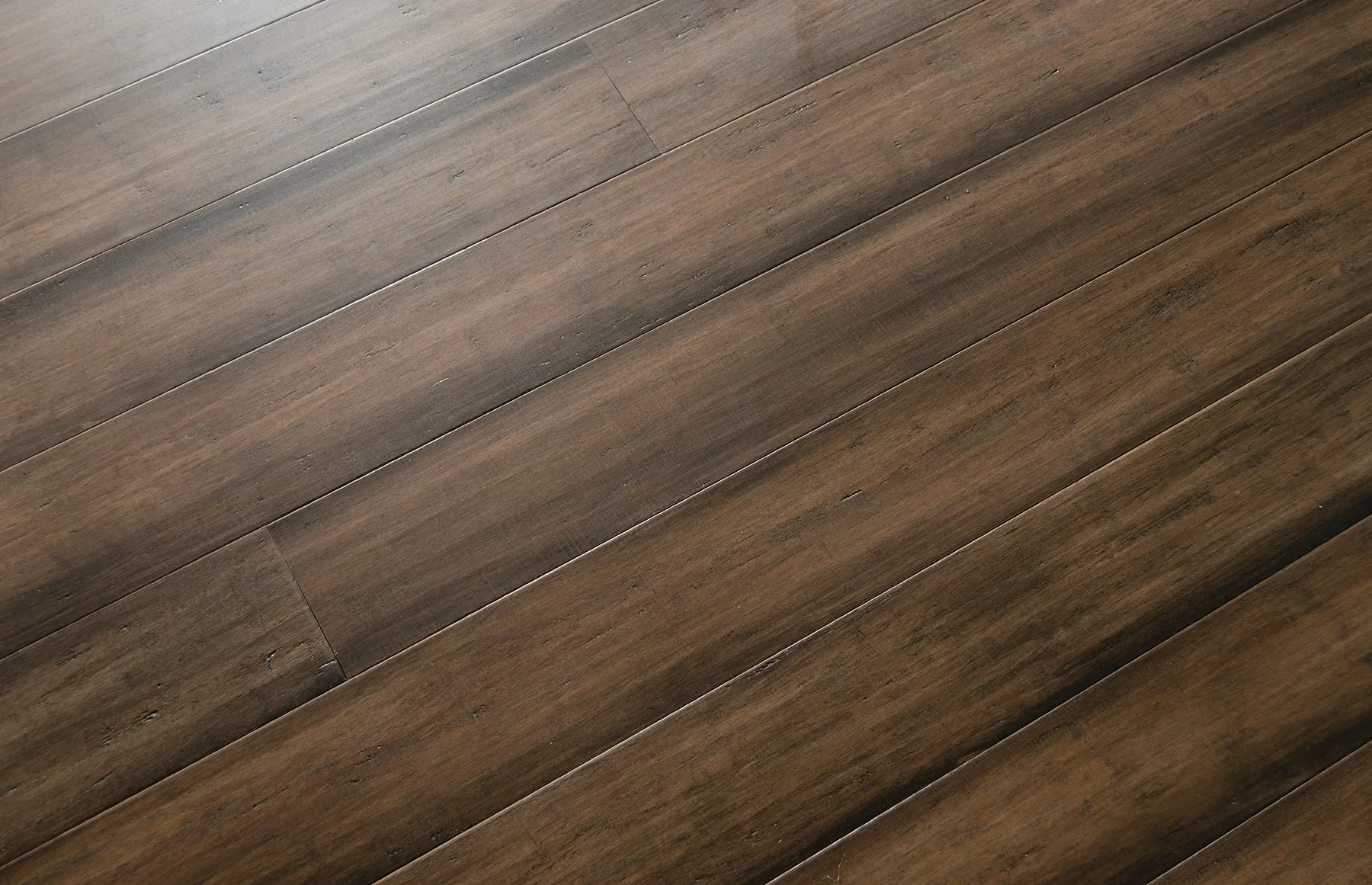 A wooden floor with horizontal planks of brown wood showing natural grain and texture.