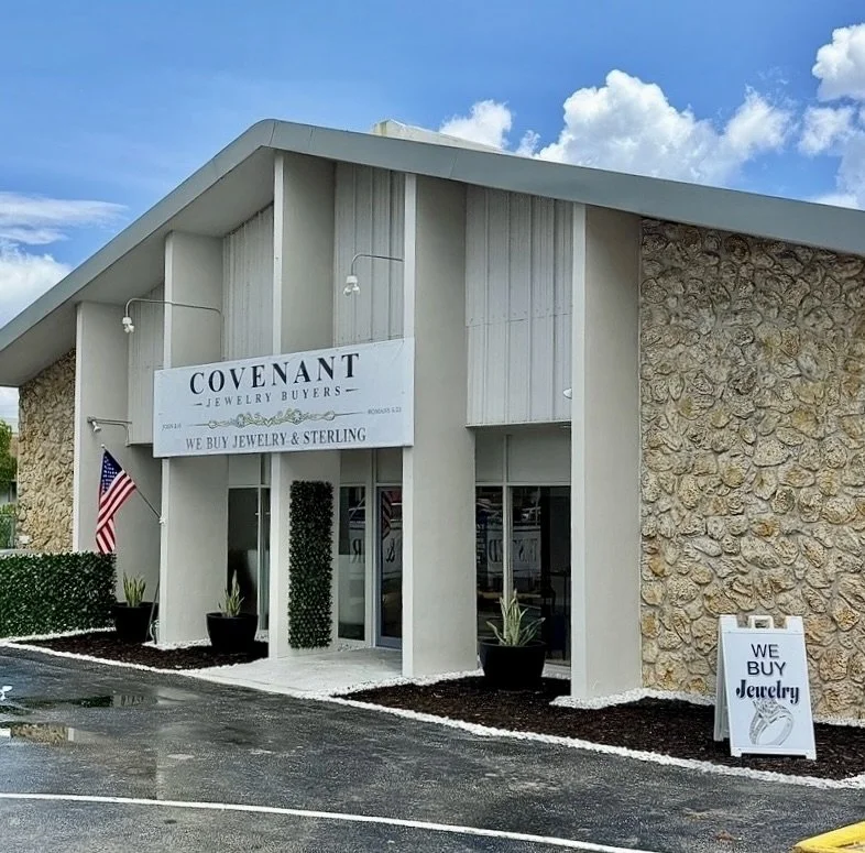 Exterior of a jewelry store named Covenant Jewelry Buyers with a sign and an American flag outside, featuring potted plants and a sidewalk