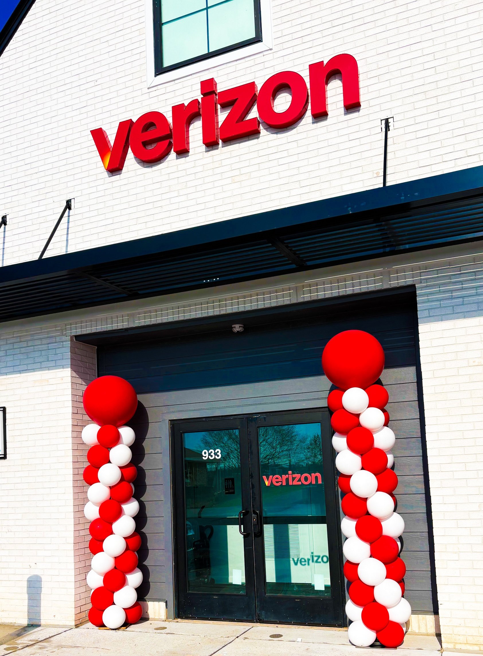 Verizon store entrance decorated with red and white balloon columns.