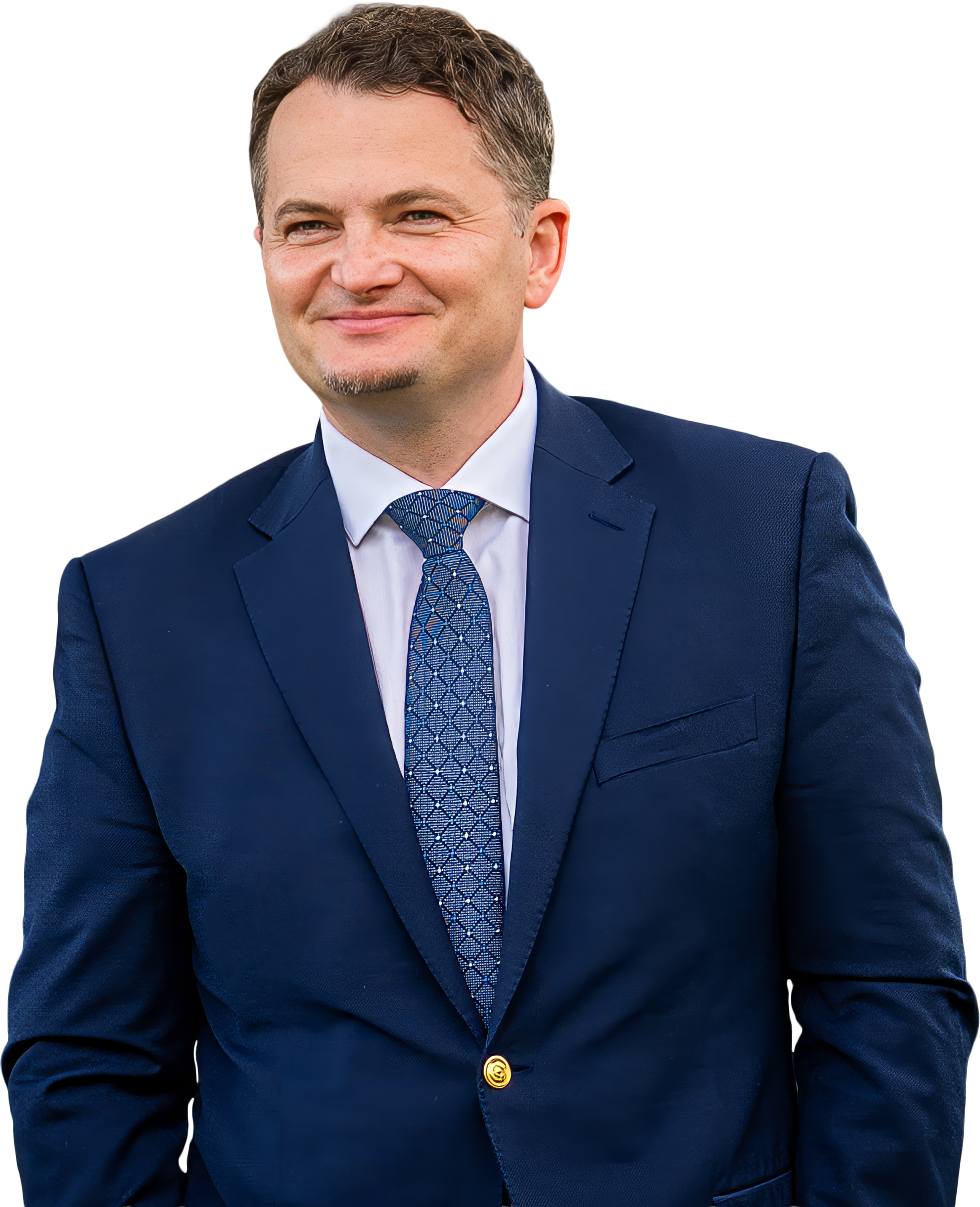 Eugen in a navy blue suit with a white shirt and patterned blue tie, smiling confidently, standing outdoors.
