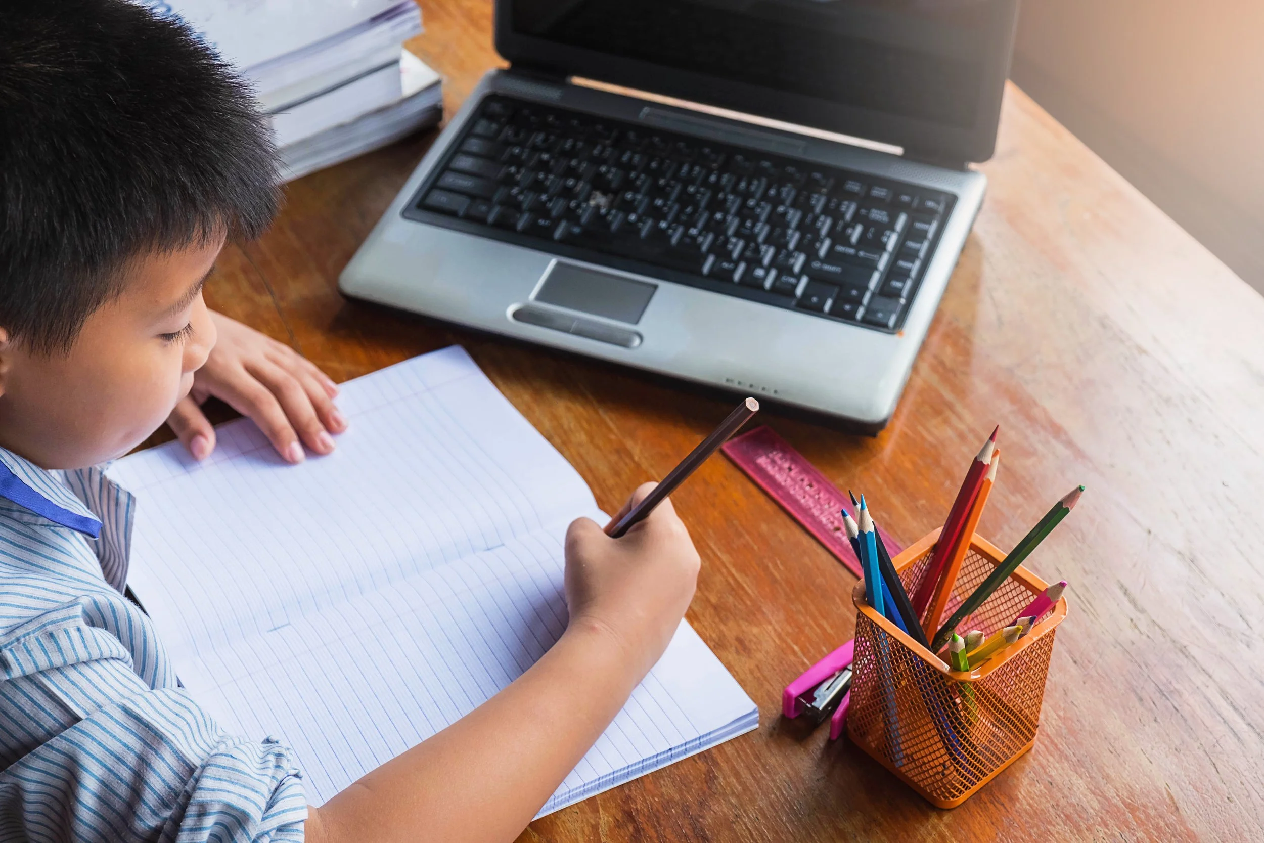 vecteezy_boy-doing-homework-with-notebook-laptop-stapler-and-a-cup_2086945.jpg