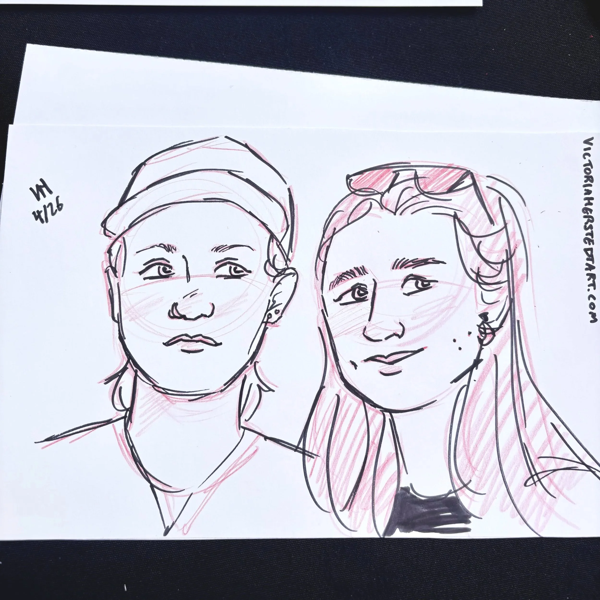 A drawing of an engaged lesbian couple done in ink and red colored pencil at an alternative wedding expo at the Victorian Belle.