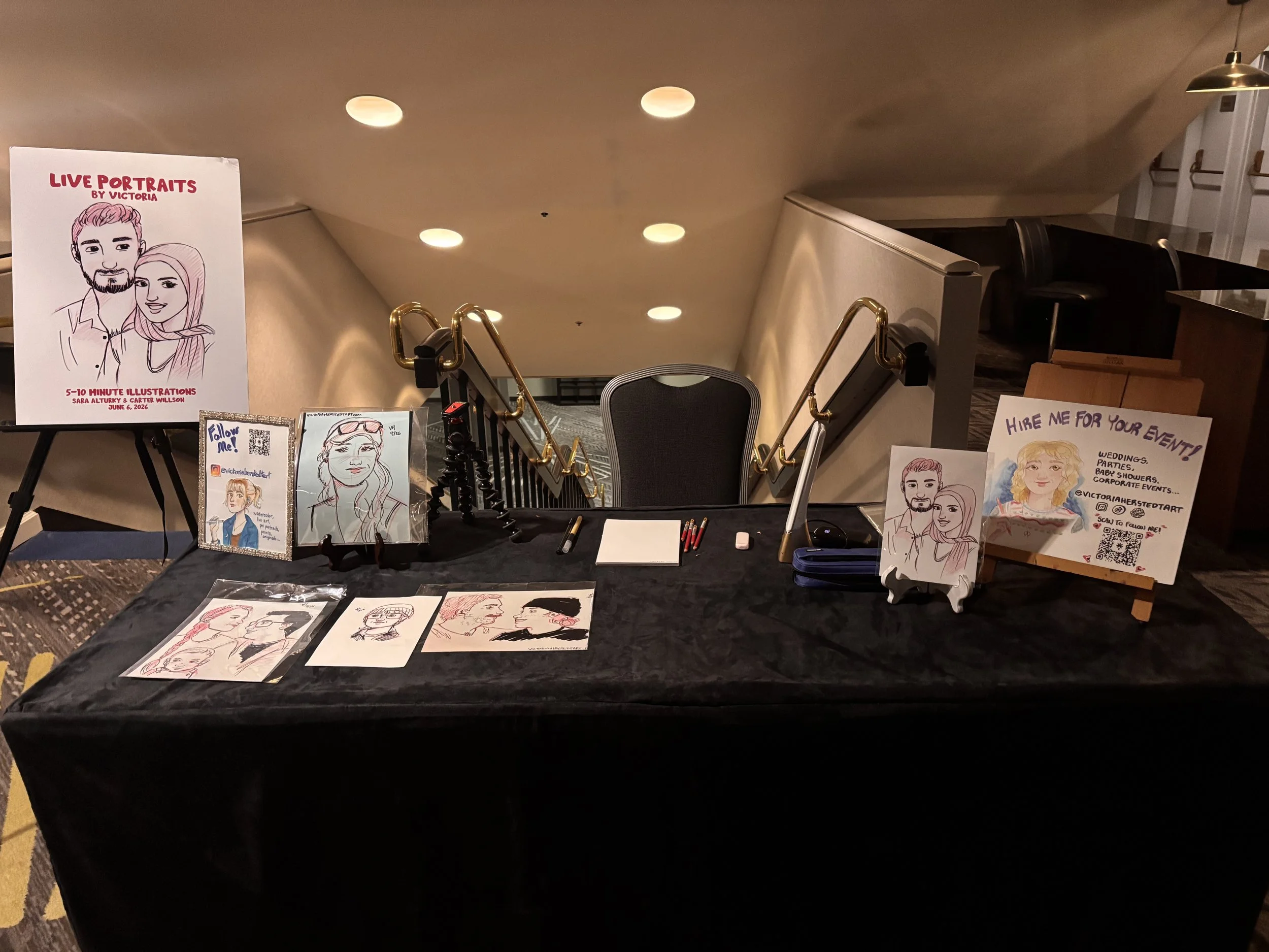 A live portrait artist's set up at a table at a wedding.