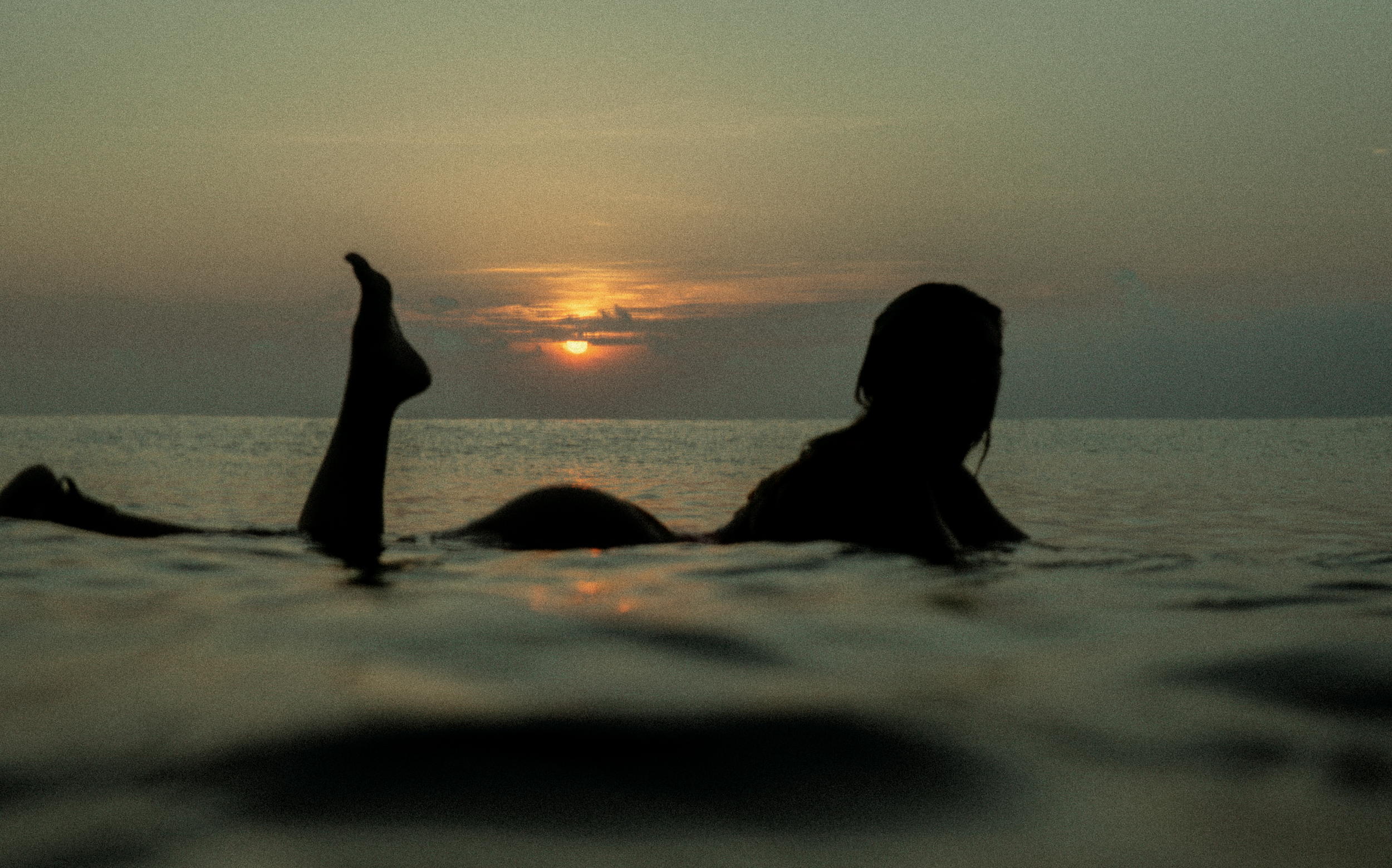 Women’s surf photography print details of female surfer in the ocean at sunset in Krui, Indonesia