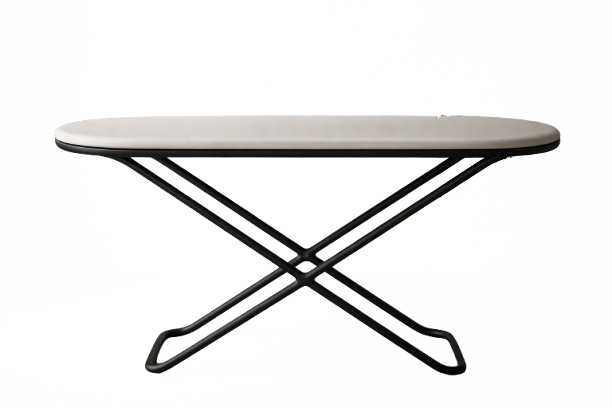 A foldable travel iron with a white top and black base, displayed against a colorful background.