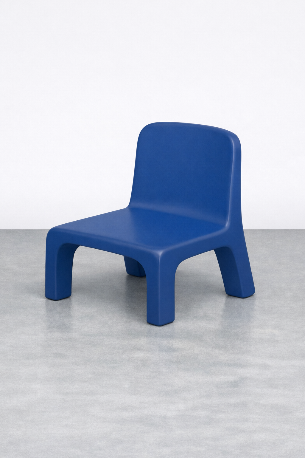 A modern blue chair with a minimalist design, placed on a gray floor against a white background.