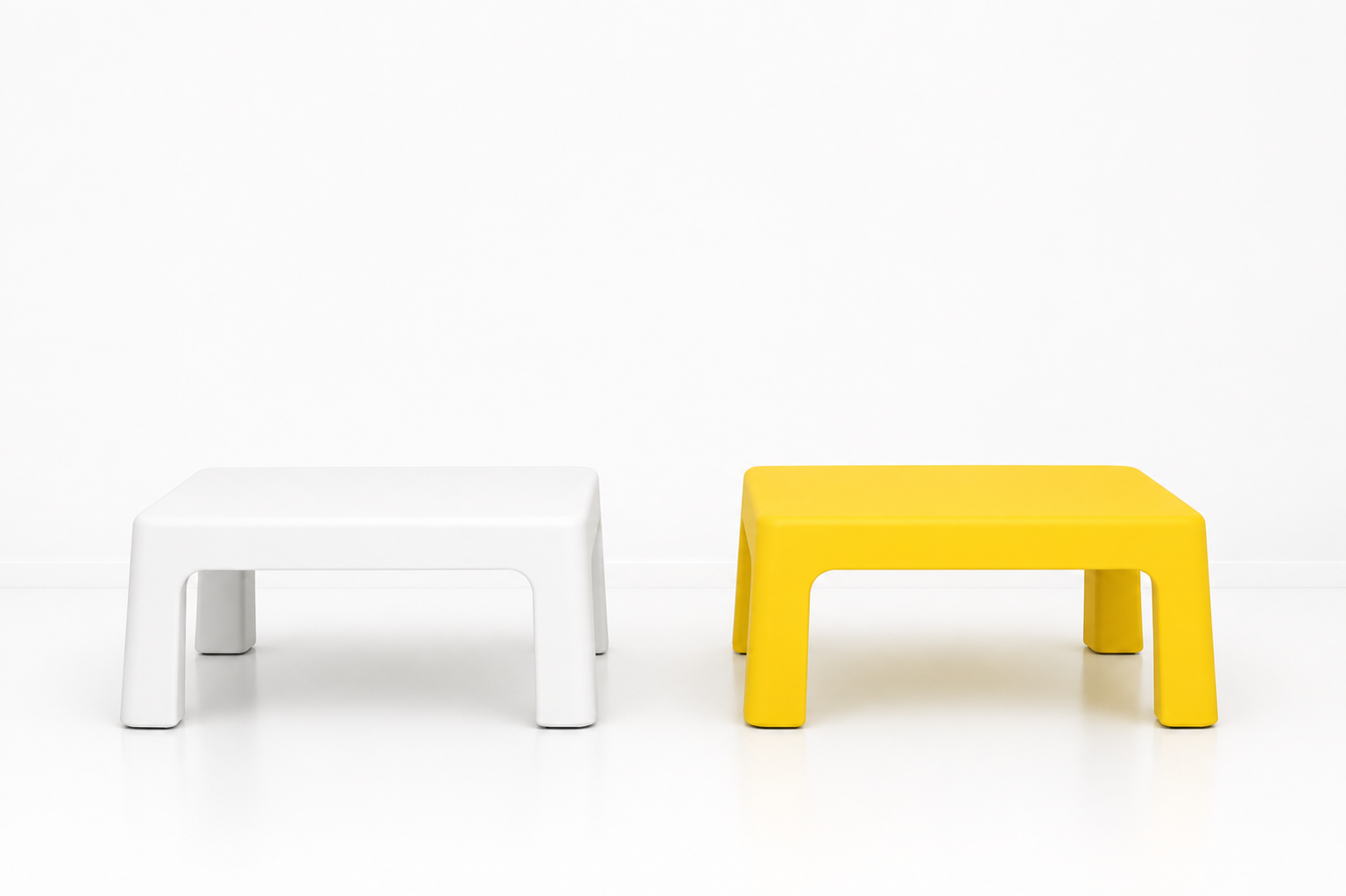 Two small modern benches, one white and one yellow, placed on a white floor against a white wall.