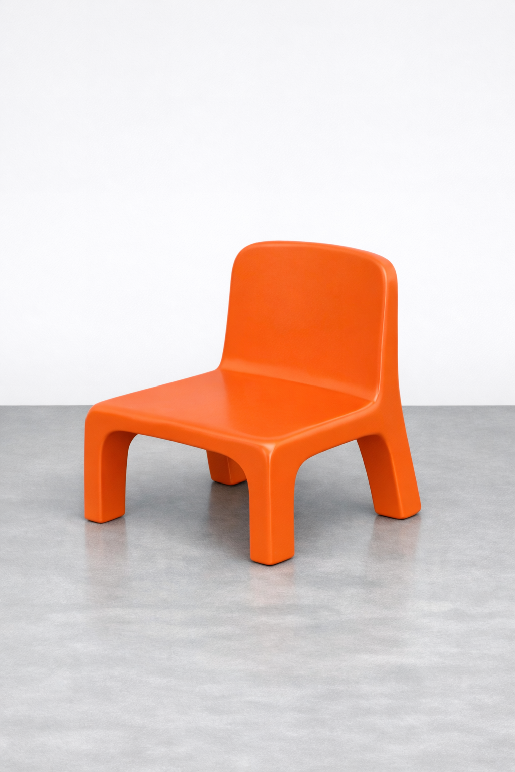 Orange modern chair with a minimalist design against a plain white wall and grey floor.