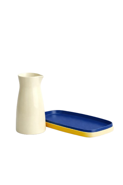 A white ceramic pitcher and a blue plastic tray on a white background.