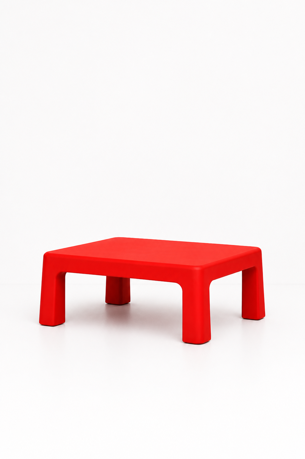 Red modern rectangular coffee table with rounded edges and thick legs on white background.