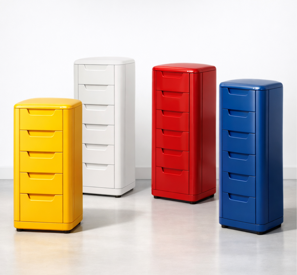 Four colorful plastic filing cabinets in yellow, white, red, and blue, arranged on a light-colored floor against a white wall.