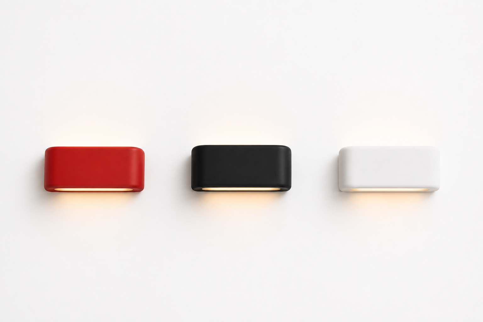 Three rectangular wall lights in red, black, and white mounted on a white wall.