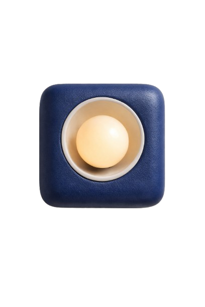 A small, white egg placed in a beige holder on a blue square platform.
