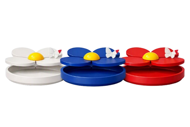 Three colorful toy storage boxes shaped like flowers in white, blue, and red with butterfly accents, each containing a yellow egg-shaped object, set against a black background.