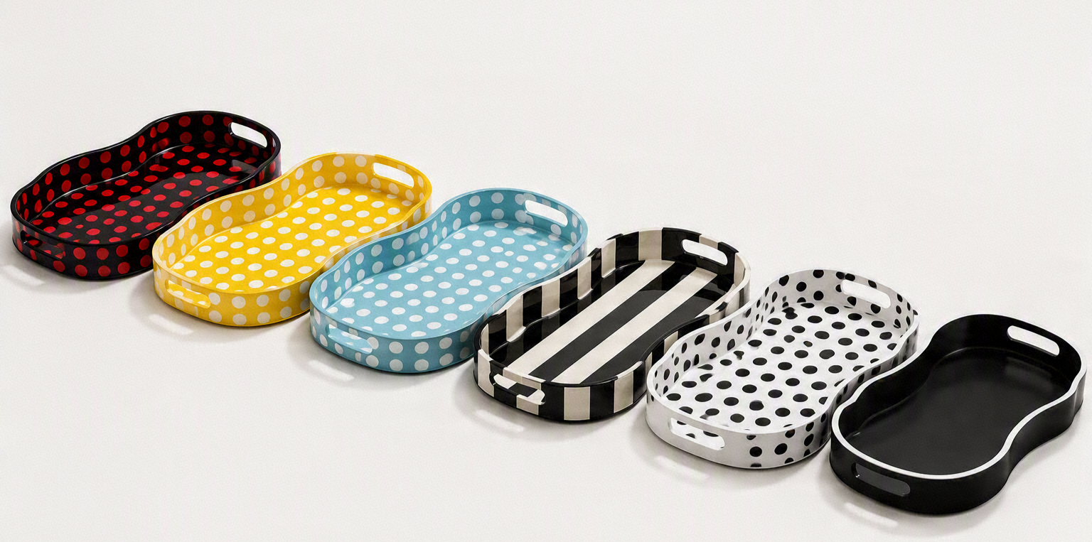 Six colorful oval-shaped trays with polka dot and stripe patterns, arranged in a row on a white background.