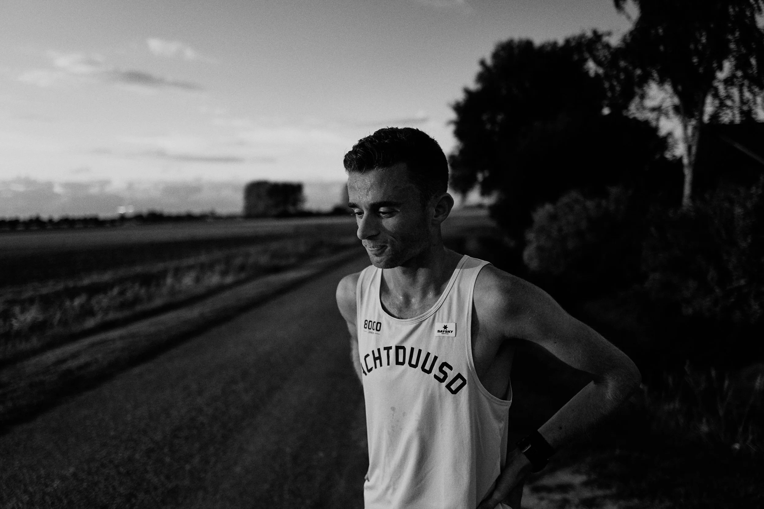 A male runner wearing a sleeveless shirt with 