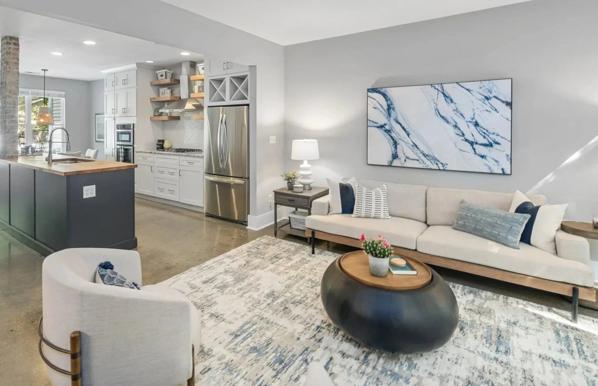 Soft gray living room with neutral furniture and blue accents in a staged Wilmington, NC home