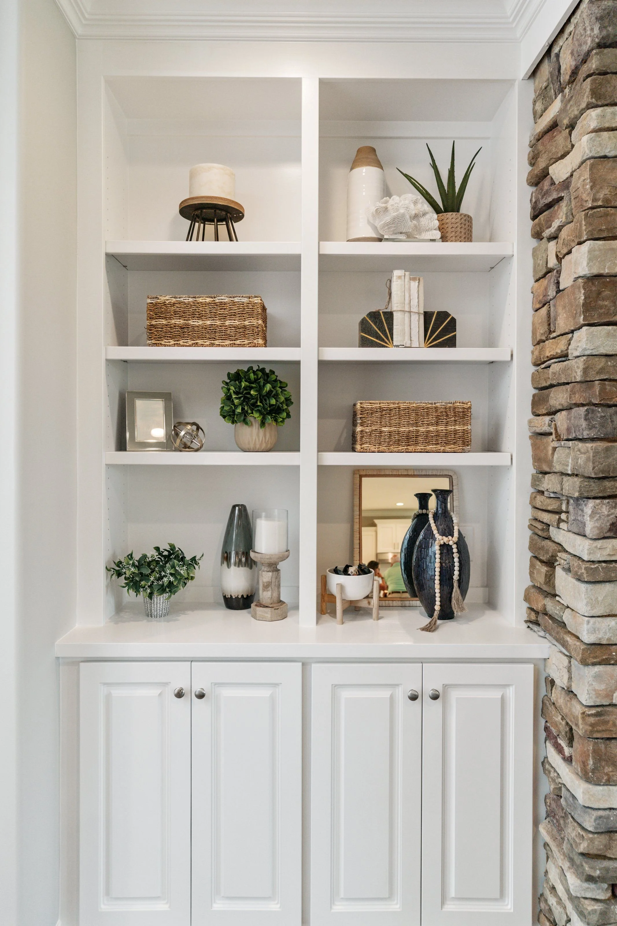 Home staging inlcudes styling white built-in shelves with plants, books, and decorative items to highlight this terrific selling feature.
