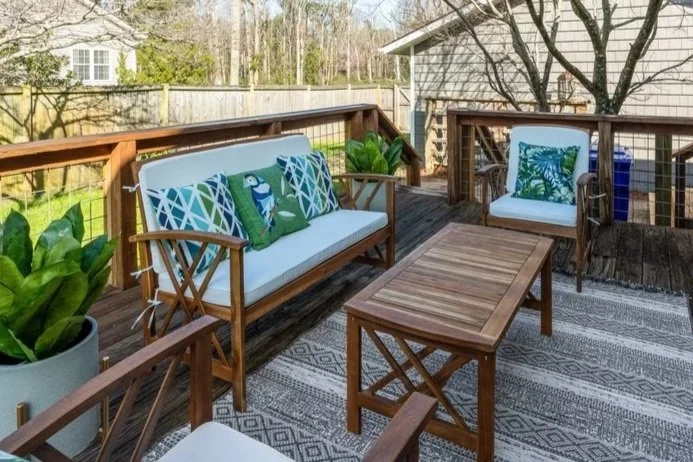 Staged outdoor seating area with patio furniture, cushions and outdoor decor