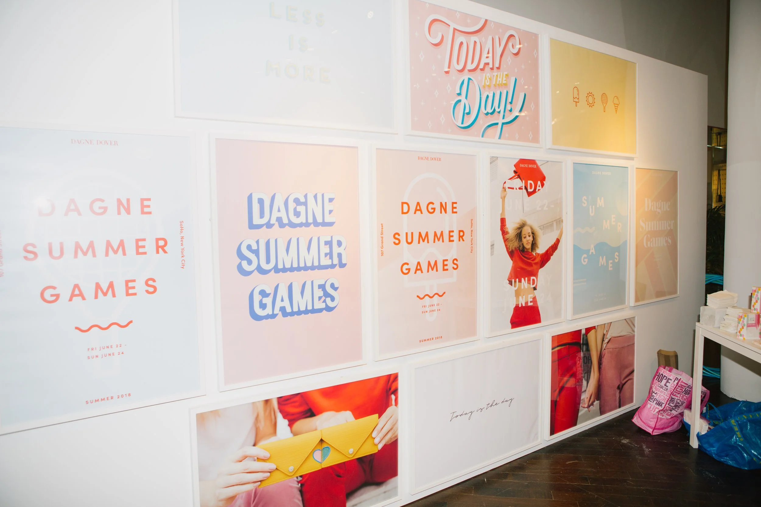 Trade project brand activation wall featuring a grid of framed fashion and lifestyle campaign prints including bold typography and product photography for a Summer Games event