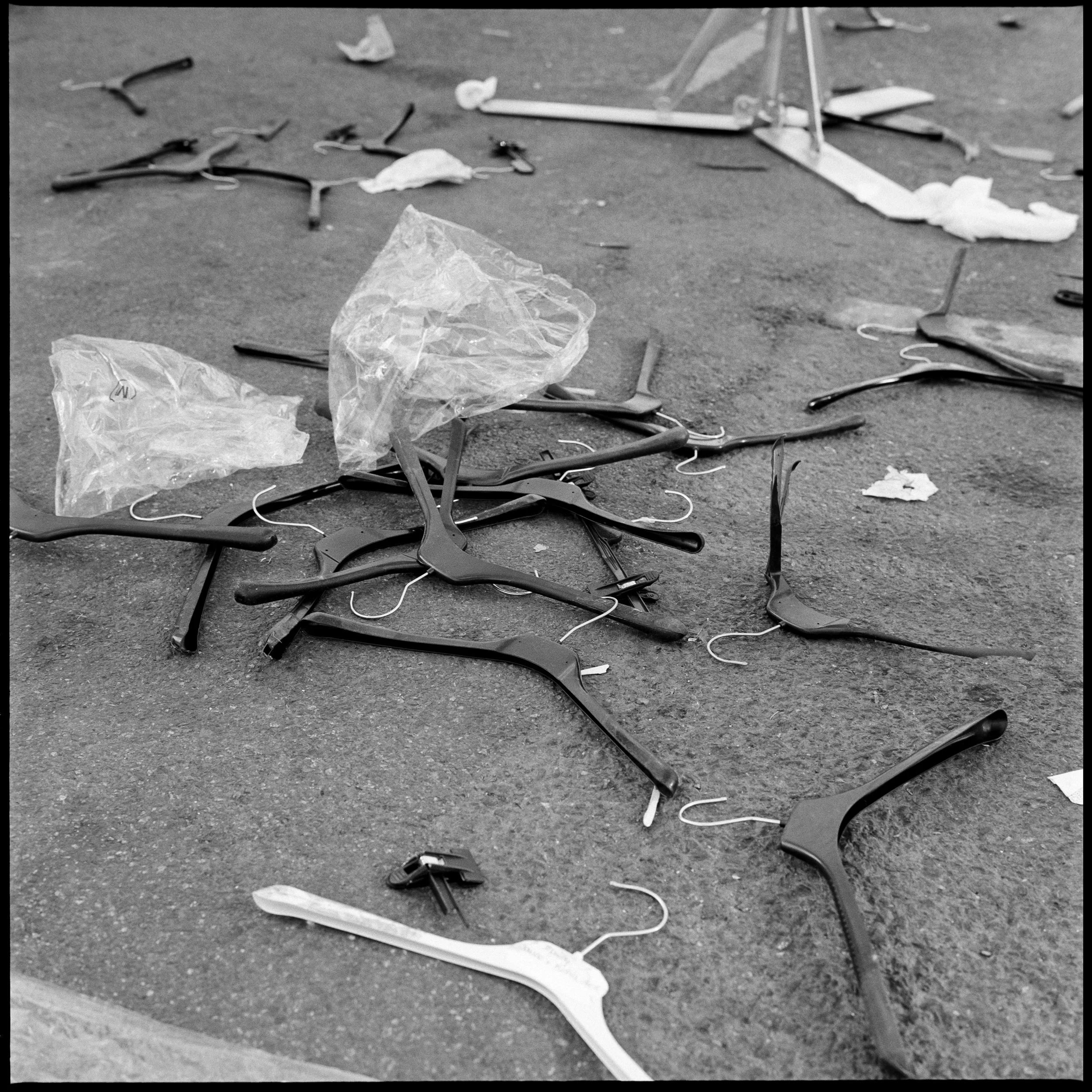 Canettes de soda en plastique, morceaux de plastique, et des trombones abandonnés sur le sol.