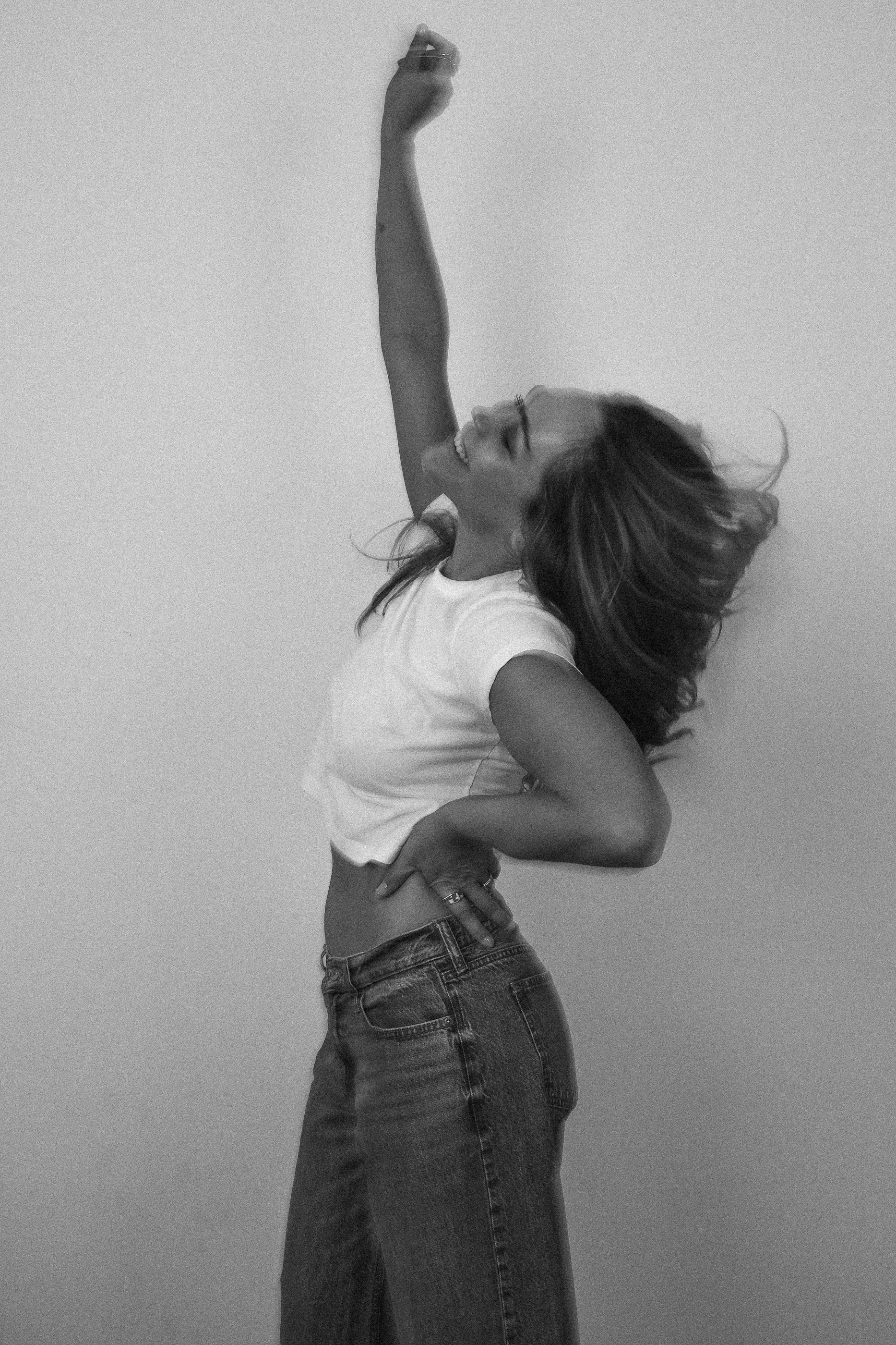 Kristin Thompson with arm raised, black and white portrait.