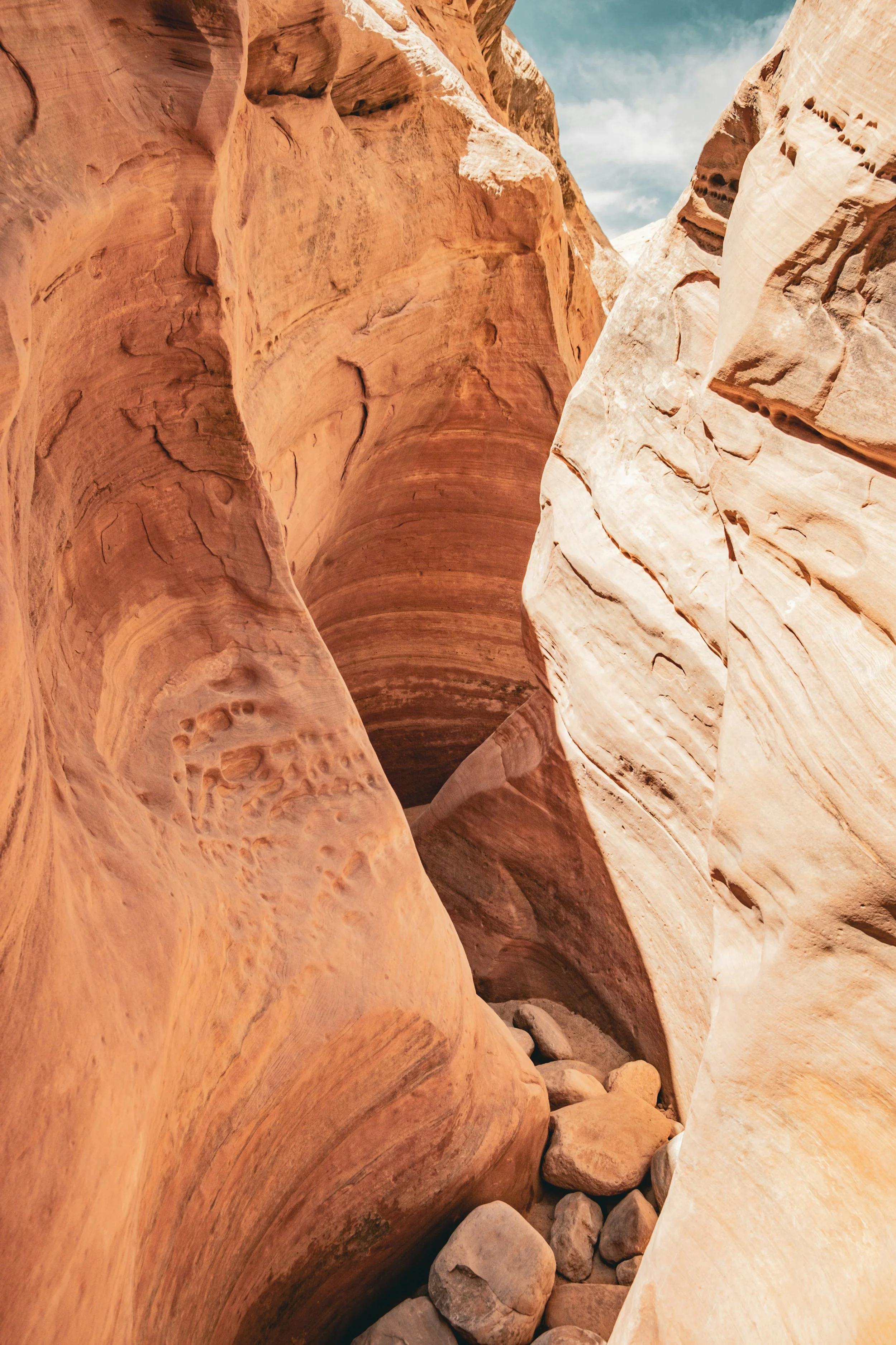 Sunlight illuminating a narrow slot canyon with curved sandstone walls