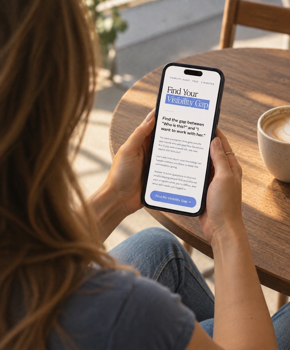 A woman with long hair holding a smartphone displaying a quiz titled 'Find Your Visibility Gap' at a wooden table with a latte in a ceramic cup nearby.