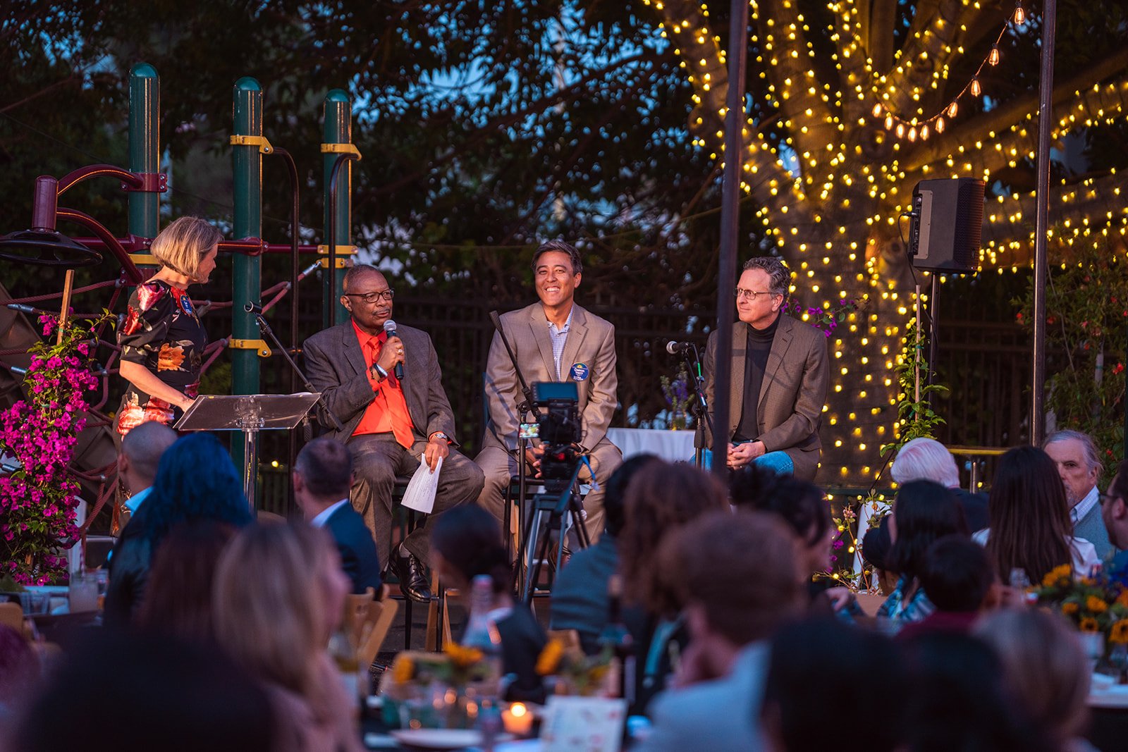 Photo of people chatting on stage at Party for the Parks in front of an audience at a night time event