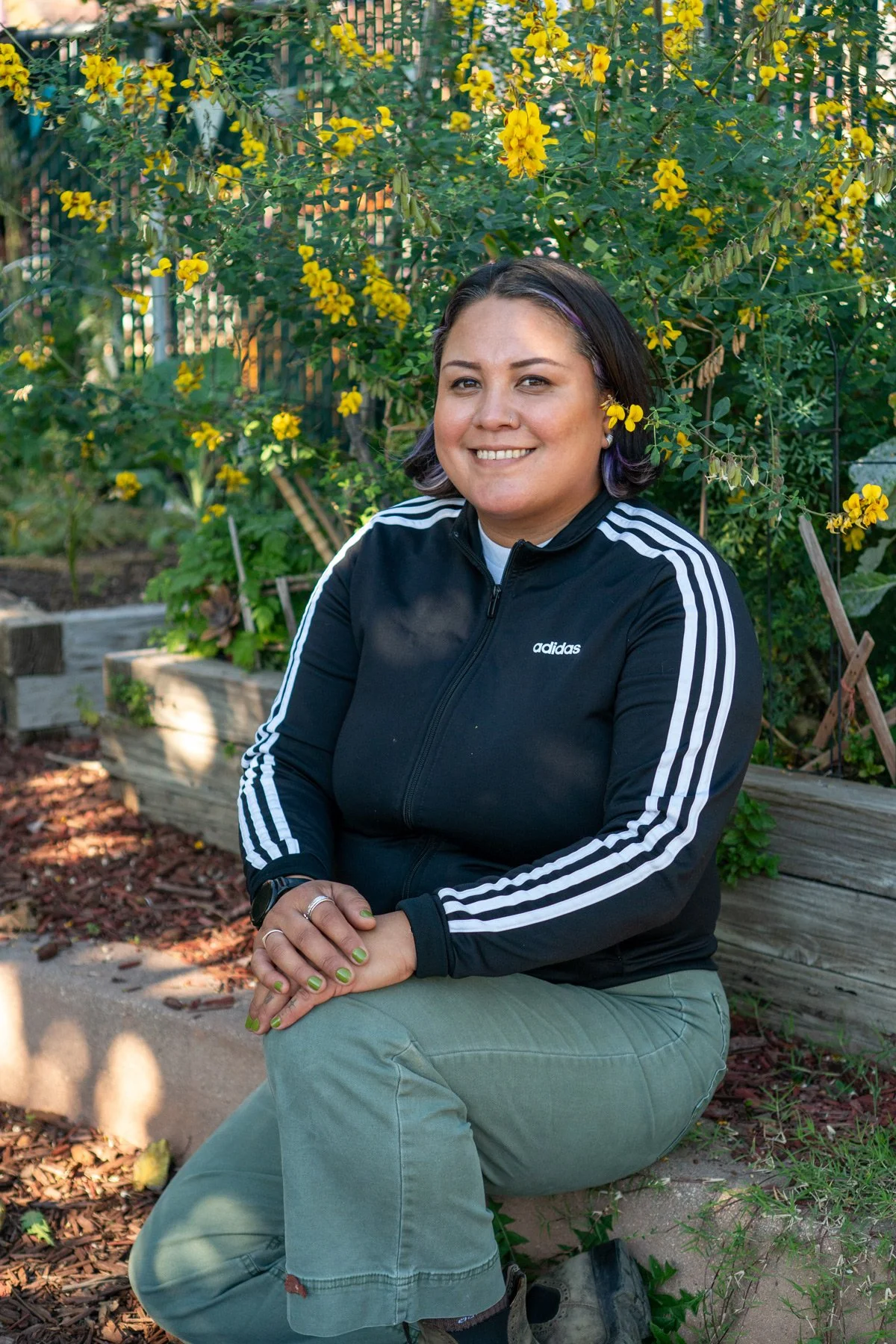 Photo of Diana sitting among garden beds