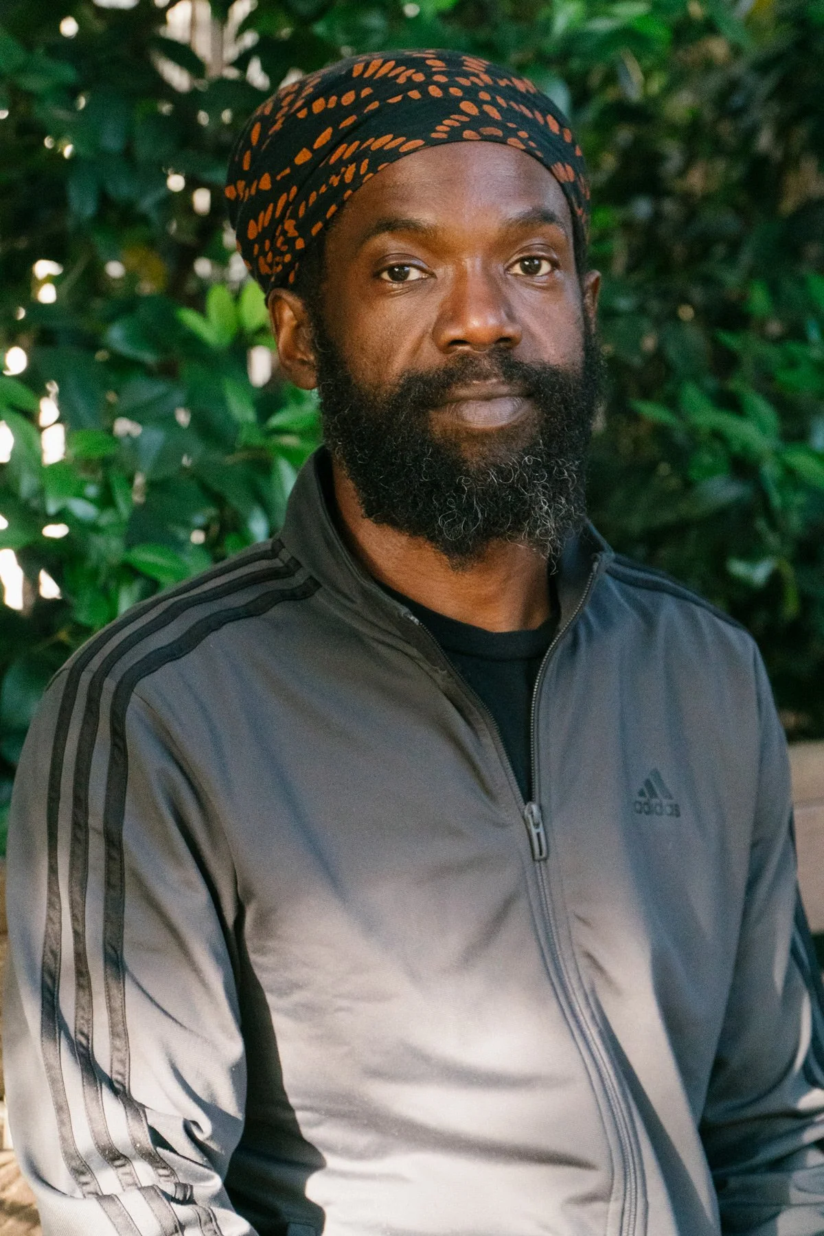 Photo of Chef Korby in front of a plant wall close up