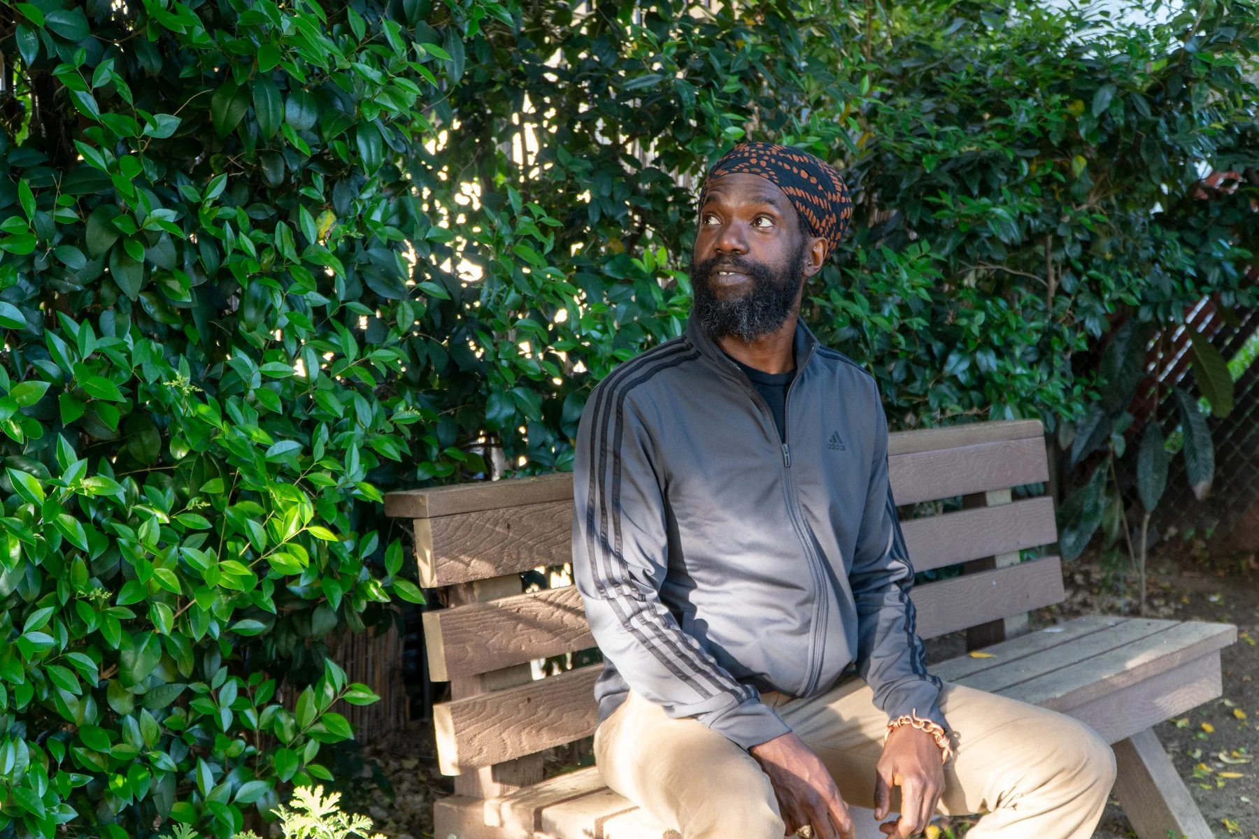 Photo of Chef Korby sitting on a park bench looking up