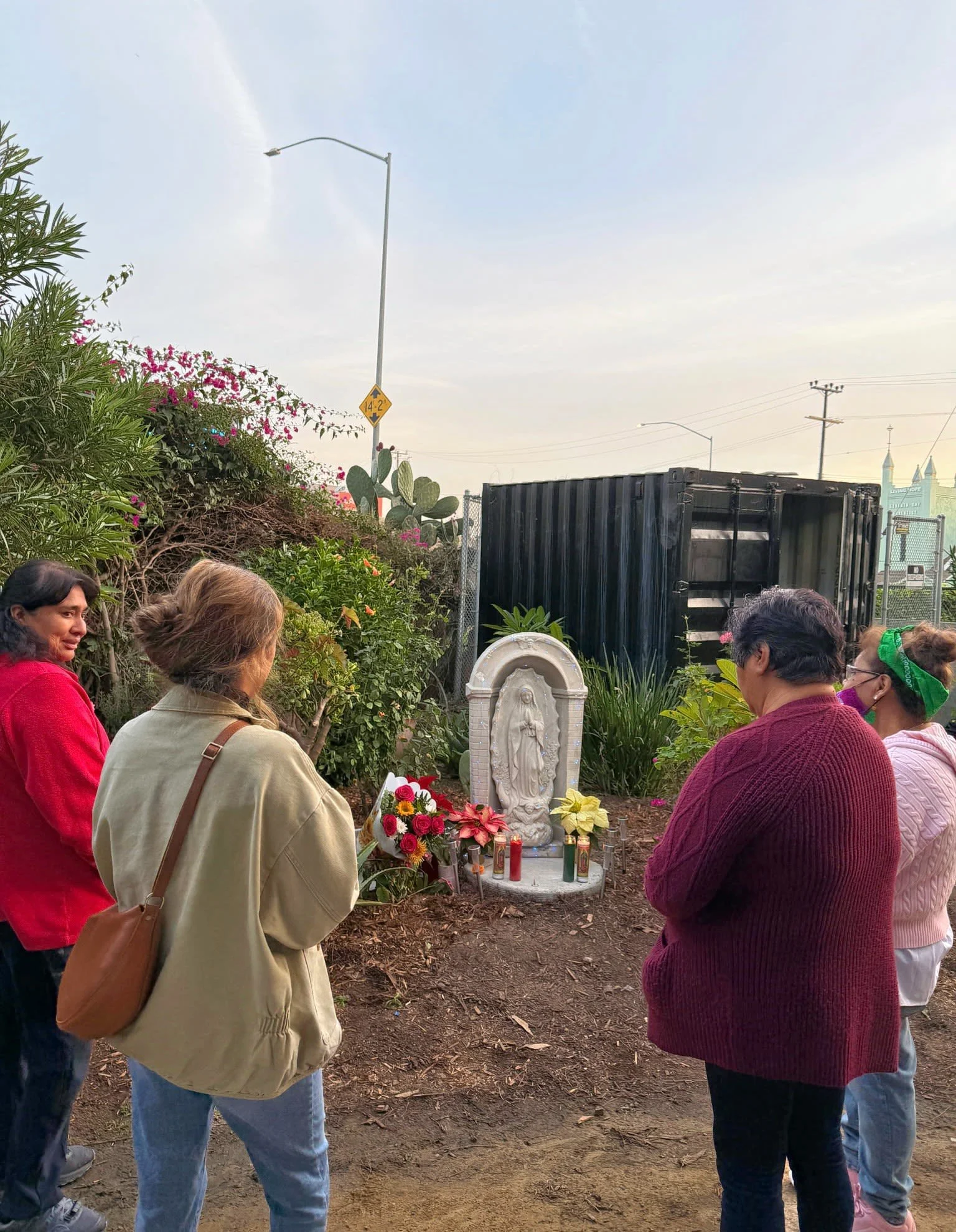 Photo of people standing around an altar with candles and flowers