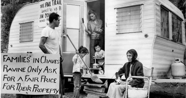 After bulldozers destroyed their Chavez Ravine home, Victoria Angustian stands in the doorway of her family’s trailer on May 13, 1959. (John Malmin / Los Angeles Times)