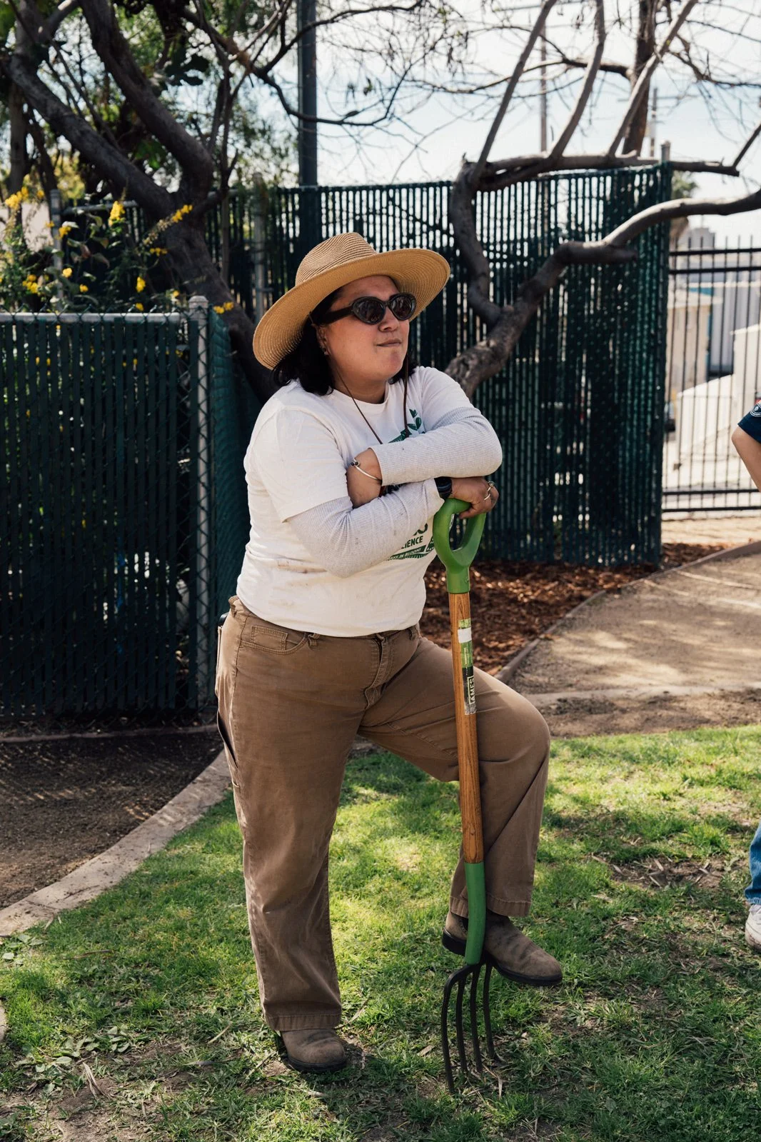 Photo of Diana in sunglasses leaning on a rake in the ground