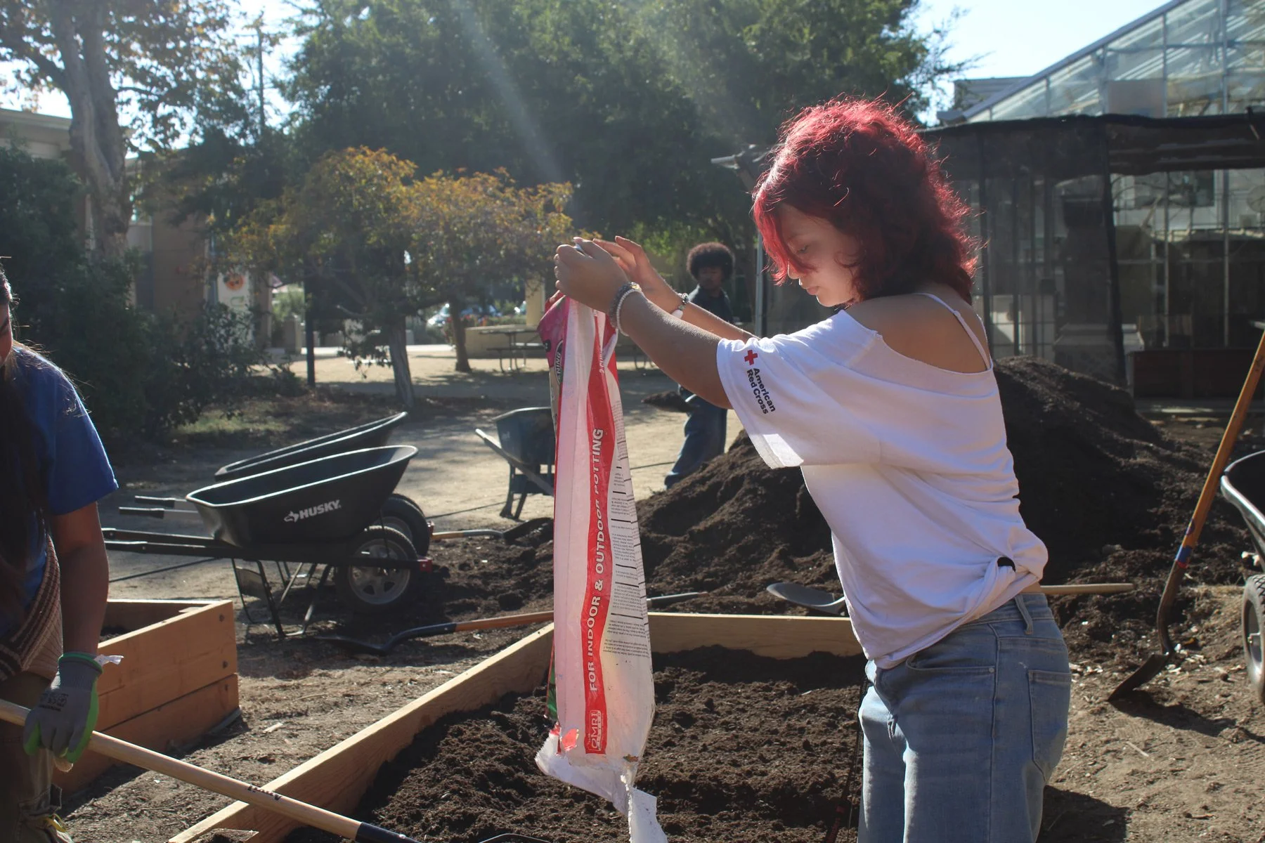 Photo of young person emptying out bag of soil