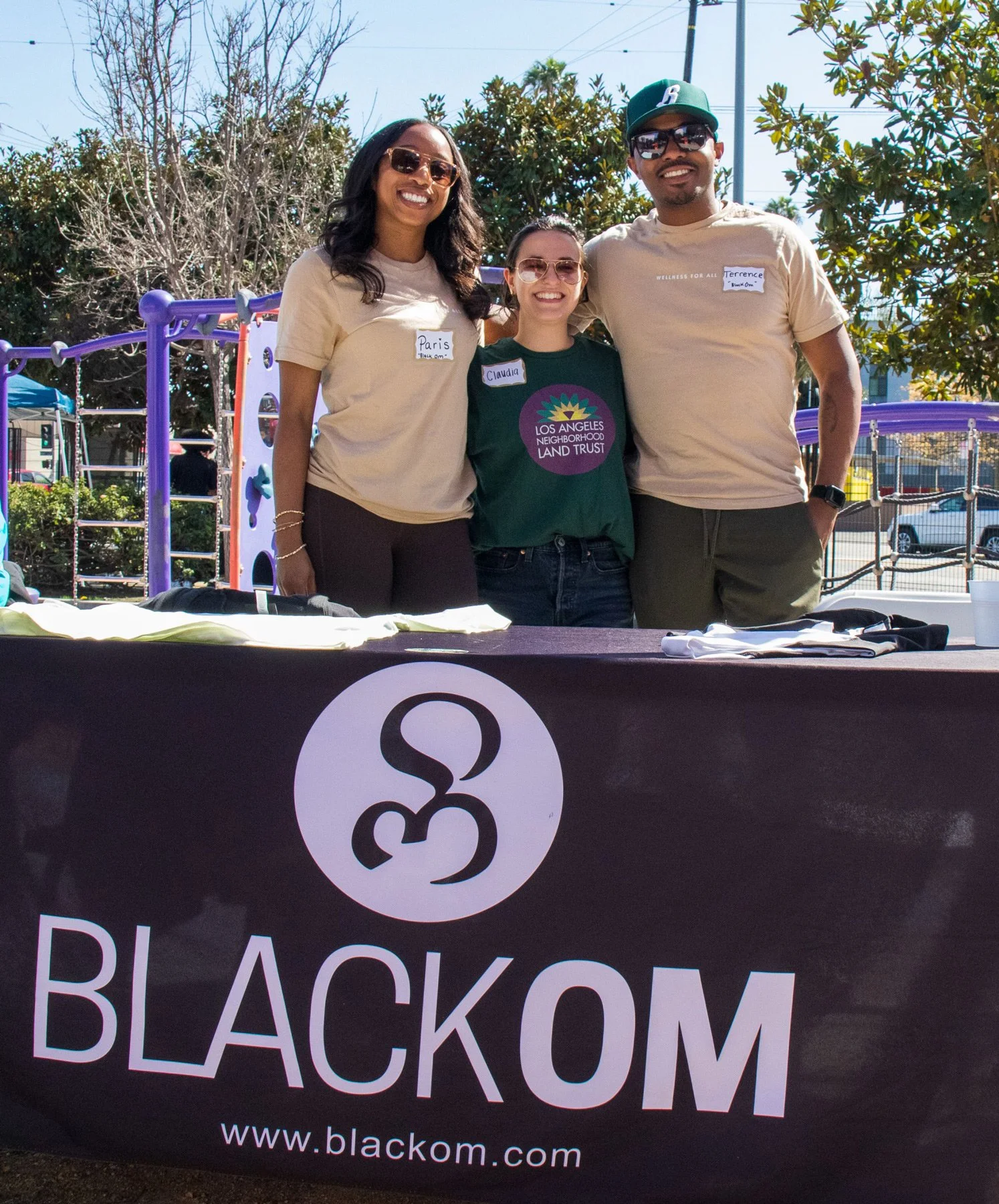 Photo of people behind a table labeled Black Om