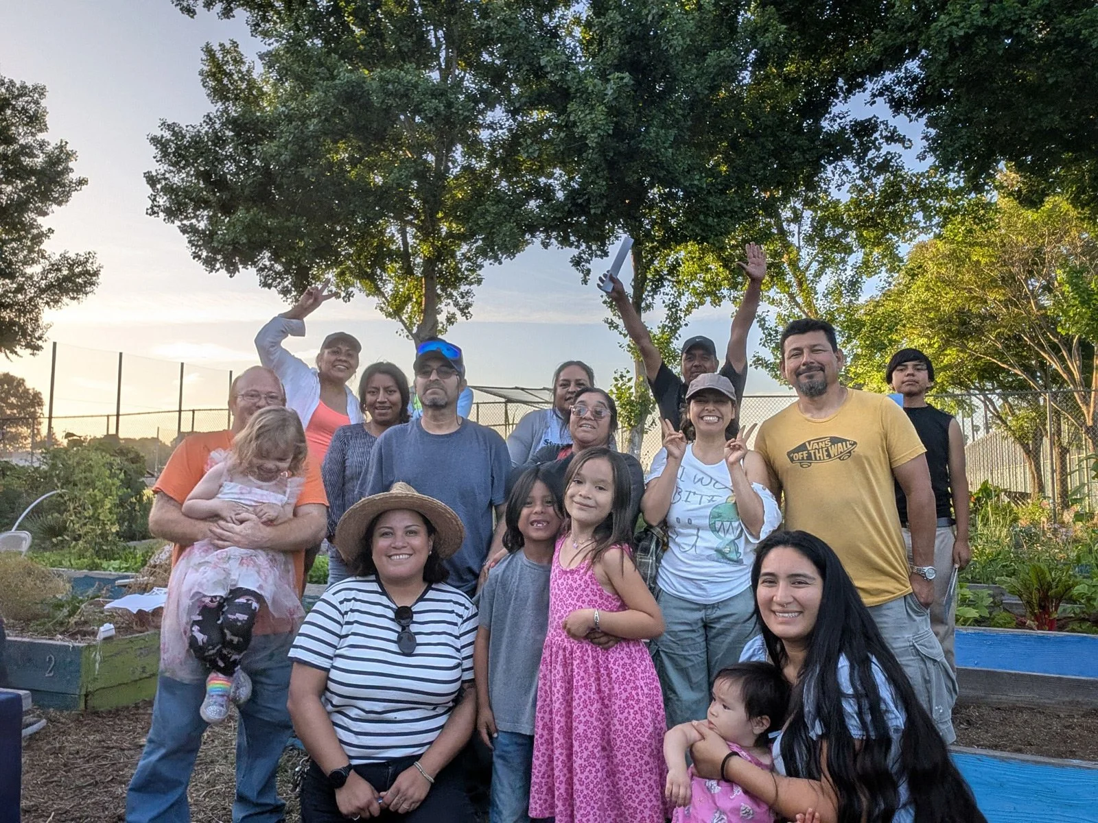 Photo of people from all ages smiling at a community garden