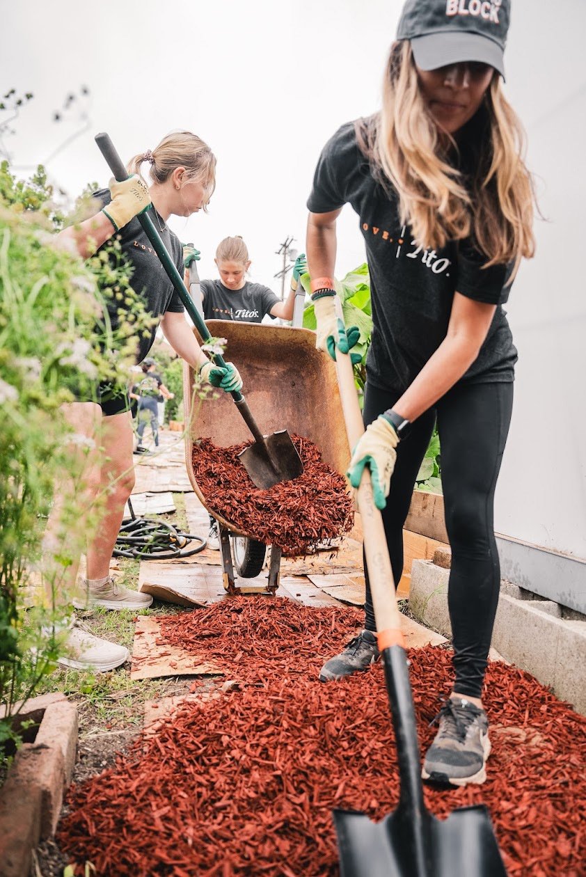 Photo of volunteers shoveling bark in a garden