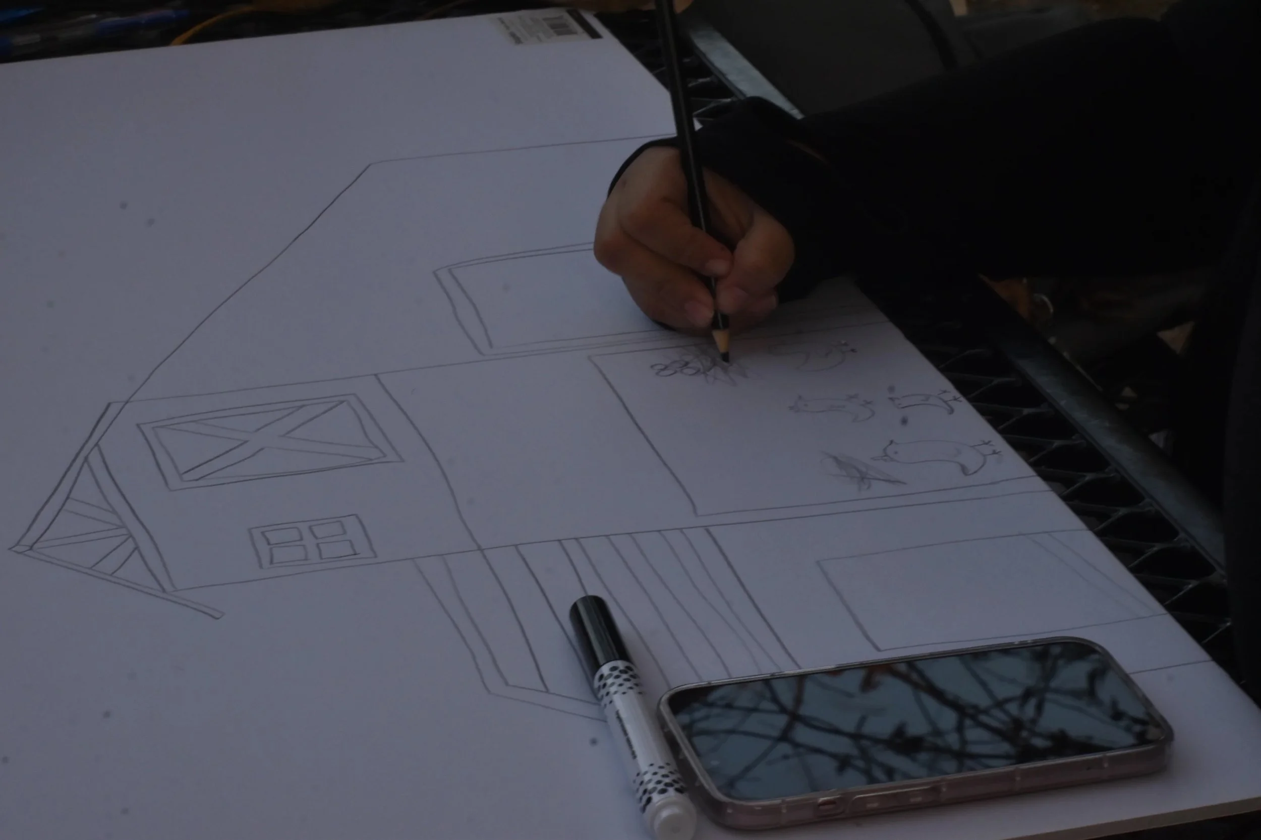 Photo of hand sketching a house
