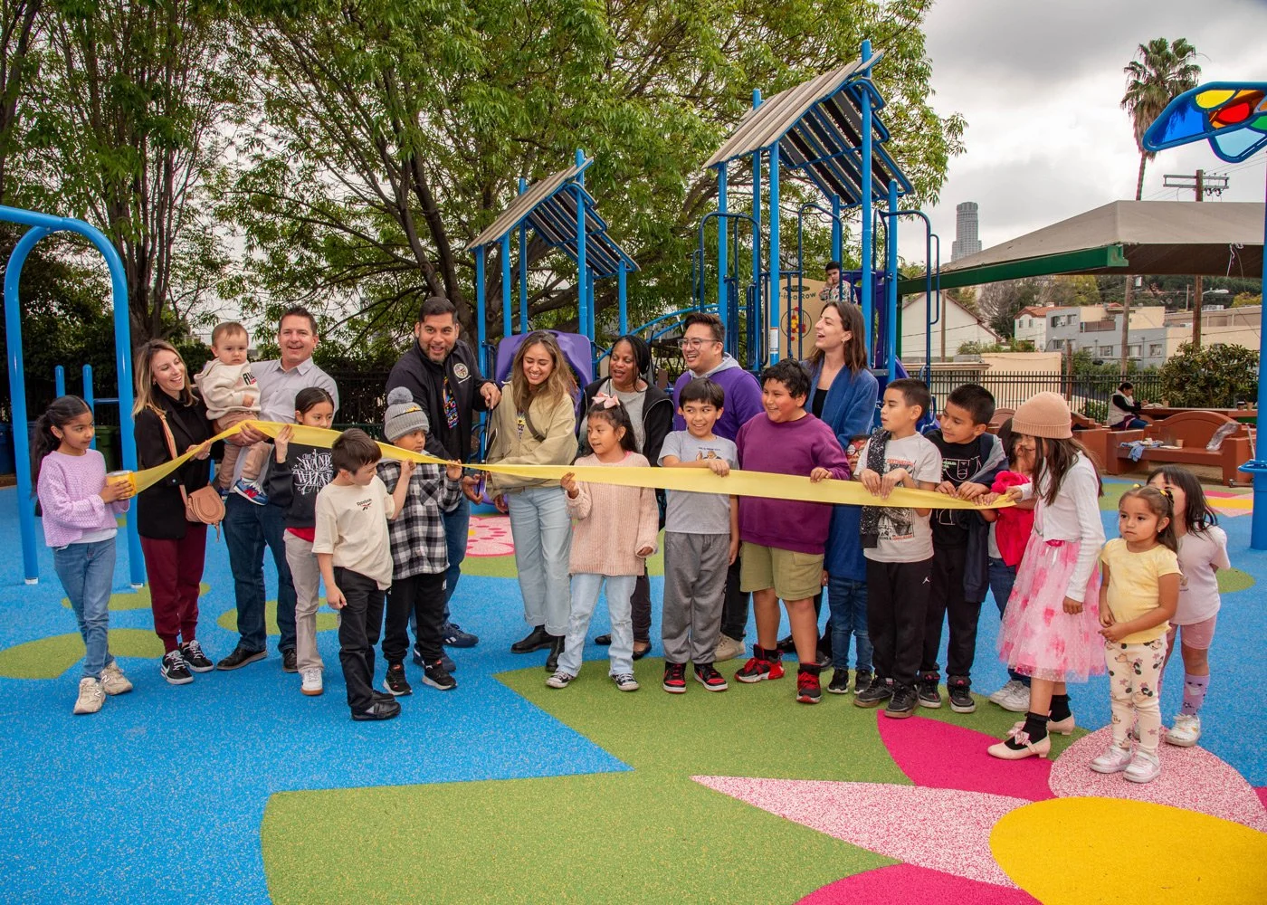 Photo of parents and children cutting ribbon in front of Unidad Park
