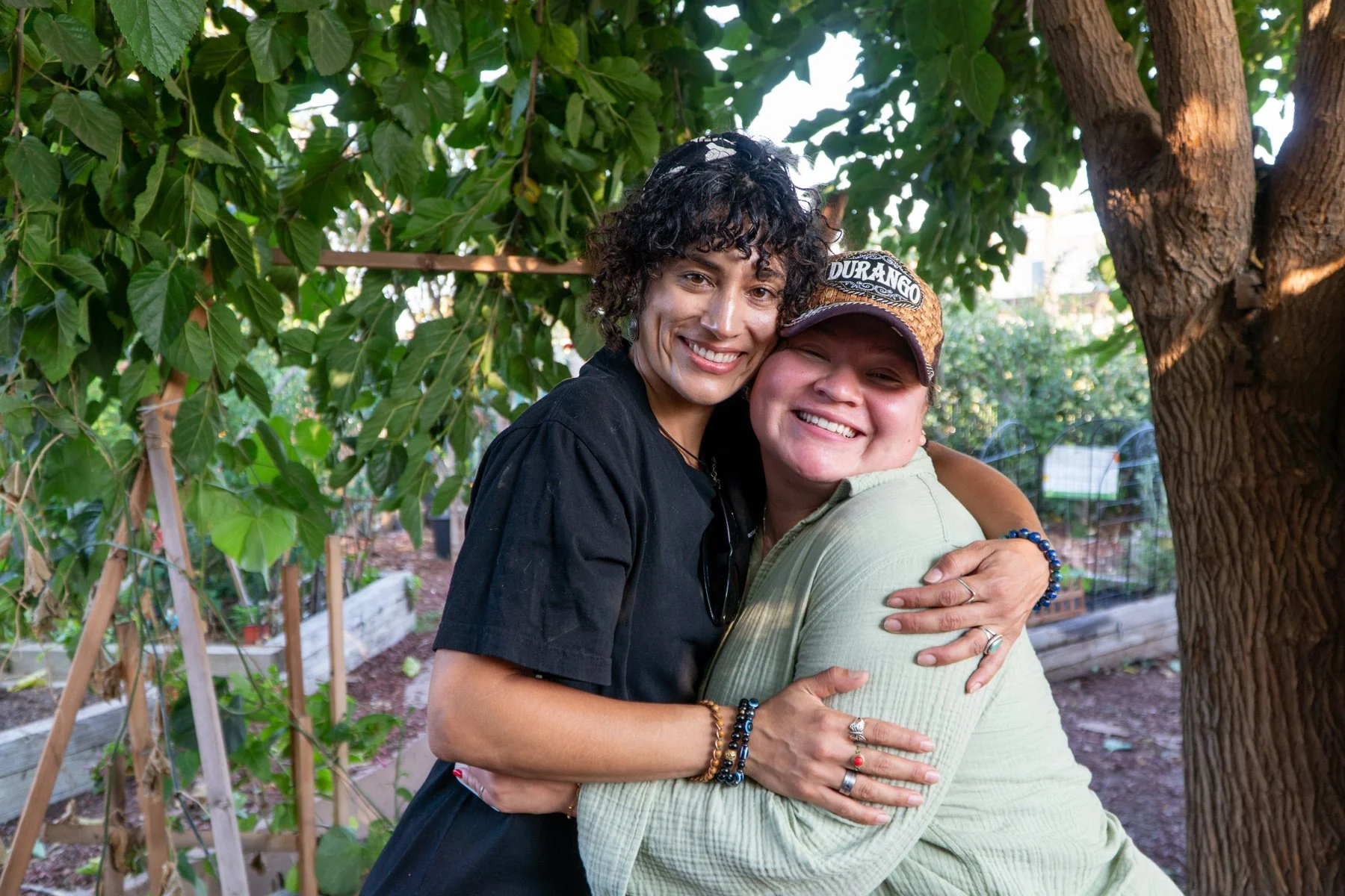 Photo of two people embracing and facing the camera in a garden