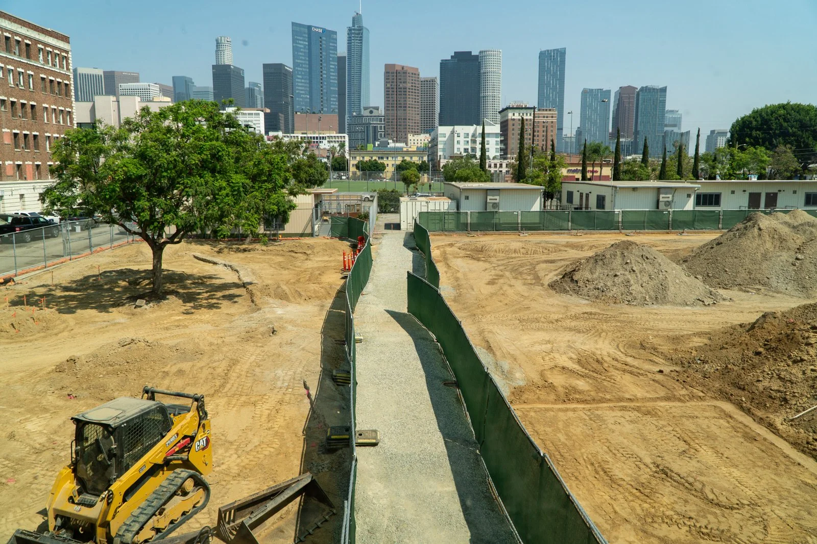 Photo of park under construction in front of the Los Angeles skylline