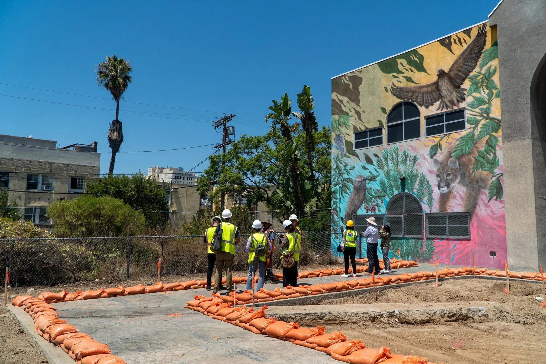 Photo of people wearing construction vests and hats in a construction park